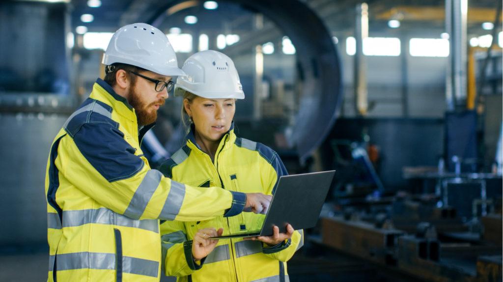 Manufacturing professionals reviewing data on laptop